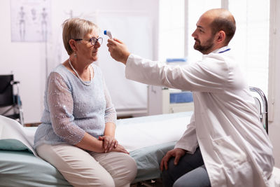 Side view of doctor examining patient at home