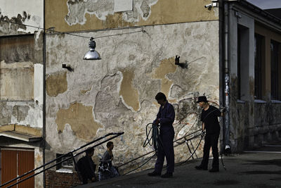 People standing by wall of building