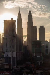 Buildings in city against cloudy sky