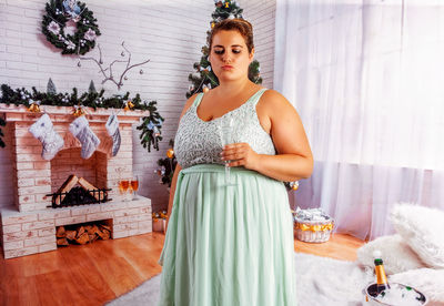 Overweight, elegant woman  with a glass of champagne in her hand.