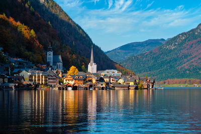 Scenic view of river by buildings against sky