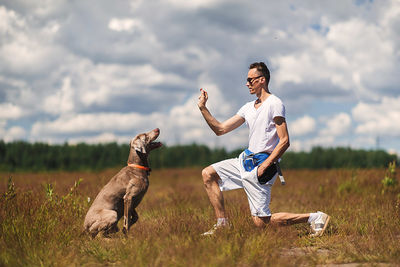 Full length of dog on field against sky