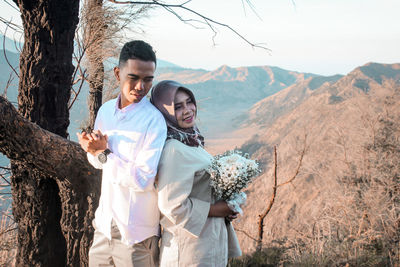 Young couple standing against mountain