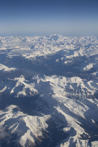 Aerial view of snowcapped mountains against sky