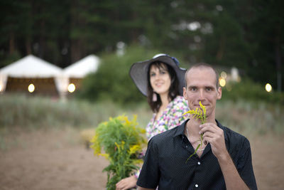Portrait of a young couple holding plant