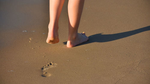 Low section of woman standing on beach