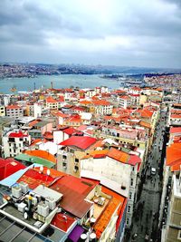 High angle view of townscape by sea against sky