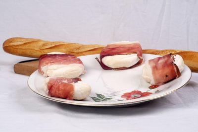 Bacon and tofu with baguette in plate on table
