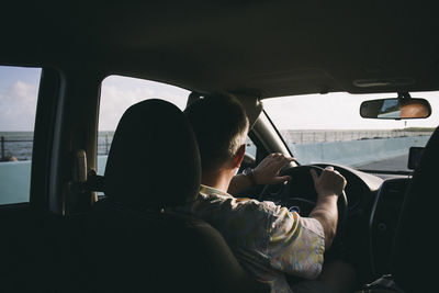 Rear view of man driving car