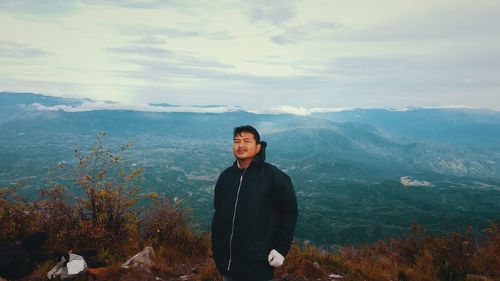 Portrait of young man in mountains against sky