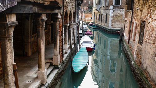 Rear view of person on canal amidst buildings