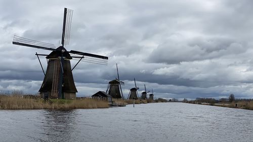 Traditional windmill on landscape against sky