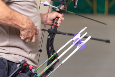 Midsection of man holding bow and arrow