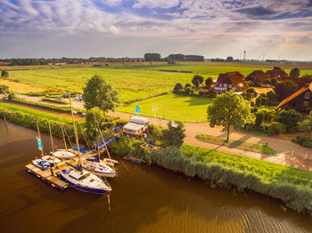 High angle view of river amidst field against sky