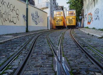 View of railroad tracks against graffiti wall