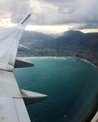 Airplane flying over sea against sky