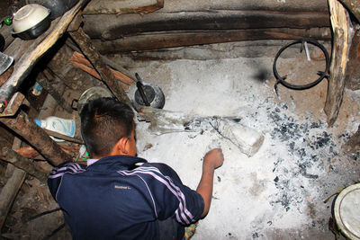 Rear view of man working on wall