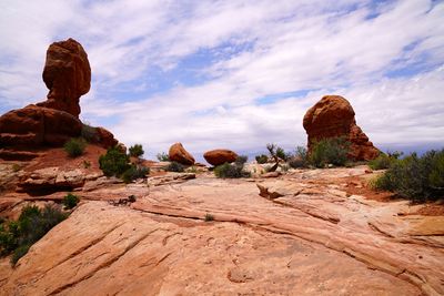 Rock formations on landscape against cloudy sky