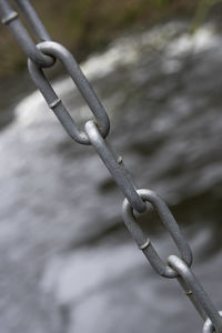 Close-up of chain on barbed wire fence