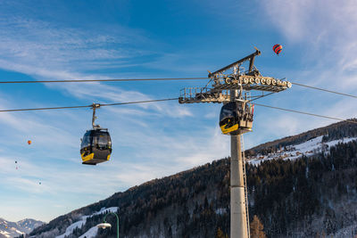 Low angle view of overhead cable car against sky