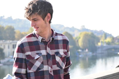 Young man standing by lake