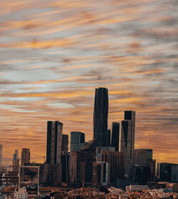 Buildings in city against sky during sunset