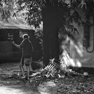 Rear view of a man standing by tree