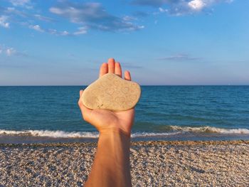 Low section of woman on beach against sky