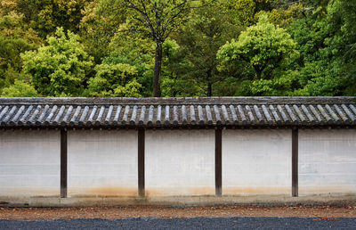 Old japanese temple wall by trees and plants