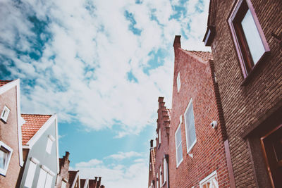 Low angle view of buildings against cloudy sky