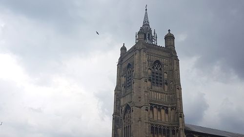 Low angle view of clock tower against cloudy sky