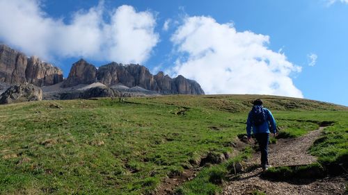 Low angle view of man hiking on mountain against sky