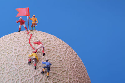 Low angle view of people against clear sky