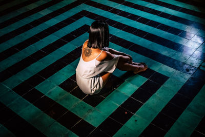 Rear view of woman sitting in swimming pool