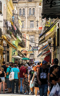 People walking on street against buildings in city