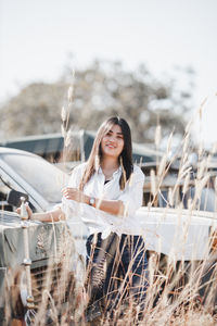 Portrait of young woman standing against the sky