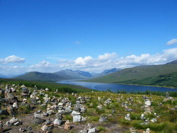 Scenic view of lake and mountains against blue sky