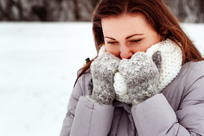 Portrait of young woman standing on snow