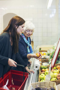 Grandmother and granddaughter shopping fruits at supermarket