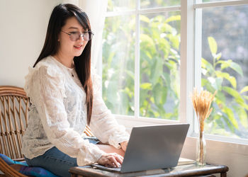 Young woman using mobile phone at home