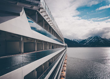 Bridge over lake by snowcapped mountain against sky