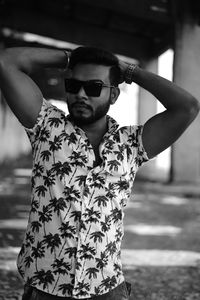 Portrait of young man wearing sunglasses standing outdoors