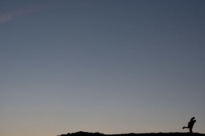 Silhouette man standing against clear sky