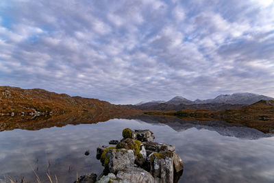 Scenic view of lake by mountain against sky