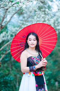 Woman holding a smiling while standing outdoors