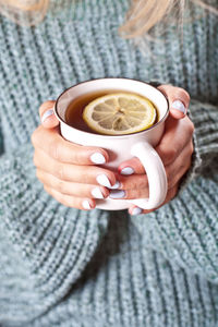 Midsection of woman holding coffee on table