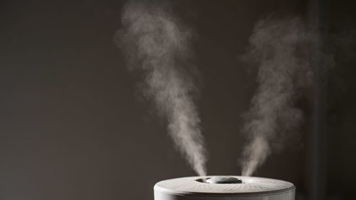 Close-up of emitting smoke against black background