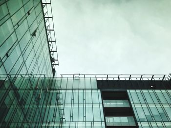 Low angle view of glass building against sky