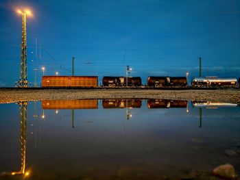 Train reflecting on water at dusk