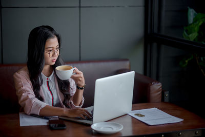 Woman sitting on table at home